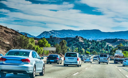 Cars on road against blue sky