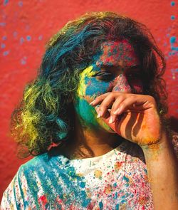 Close-up of woman covered with multi colored powder paint