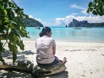 Rear view of man sitting on beach