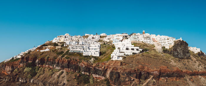 Low angle view of rock formations against clear blue sky