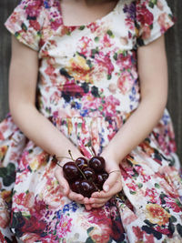 Girl holding cherries