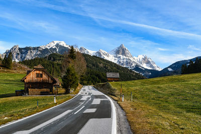 Road leading towards mountains against sky