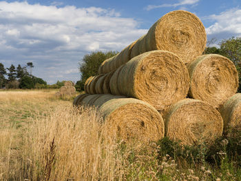 Hay bales on field against sky