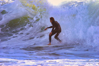 Full length of man splashing water in sea