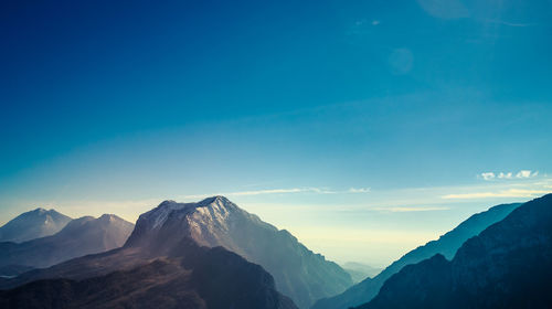 Scenic view of mountains against blue sky