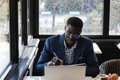 Man looking at camera while sitting on table