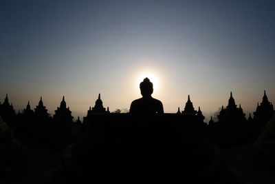 Low angle view of statue at temple against sky during sunset