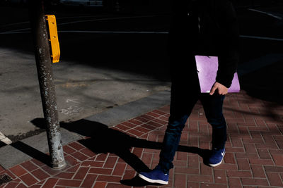 Low section of woman standing on sidewalk