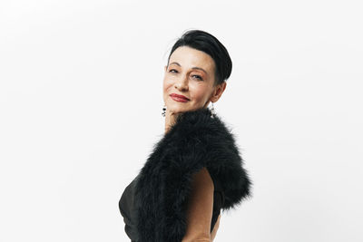 Portrait of young woman standing against white background