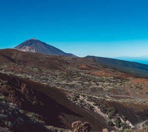 Scenic view of mountain range against blue sky