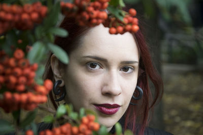 Portrait of beautiful woman by berries growing on tree