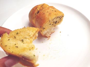 Close-up of hand holding bread in plate