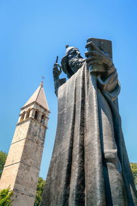 Low angle view of statue against temple against clear sky