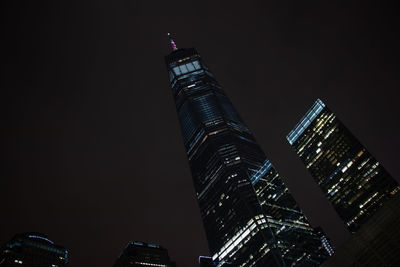 Low angle view of illuminated buildings against sky at night