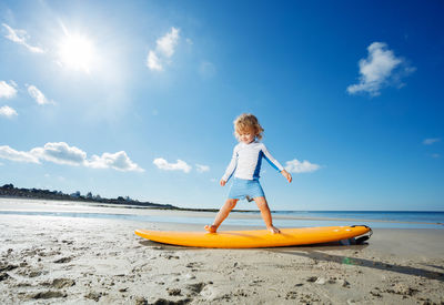 Full length of woman standing on boat on beach against sky
