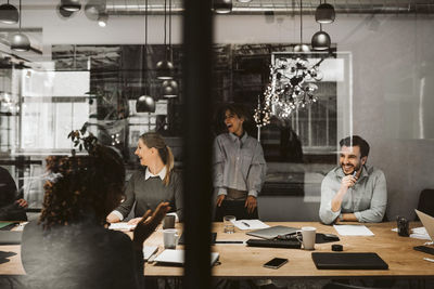 Business colleagues laughing during meeting in board room