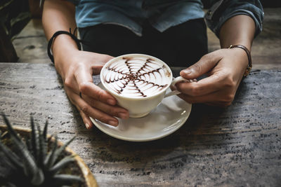 Midsection of person holding hot chocolate