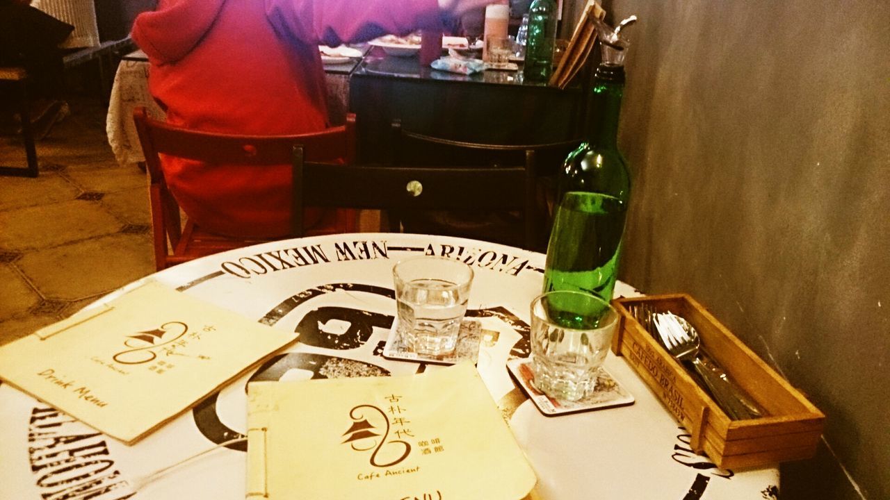 indoors, table, still life, book, home interior, wood - material, chair, text, paper, absence, education, variation, close-up, no people, empty, drink, high angle view, communication, bottle, restaurant