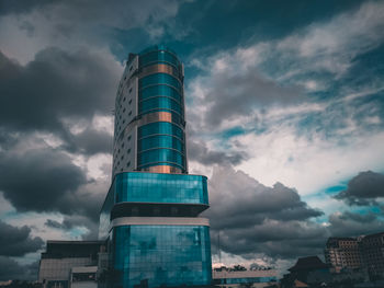 Low angle view of buildings against cloudy sky