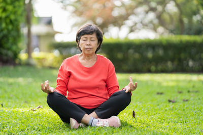 Portrait of young woman exercising on field