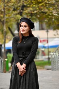 Portrait of beautiful woman standing against tree