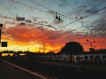 Railroad station against sky during sunset