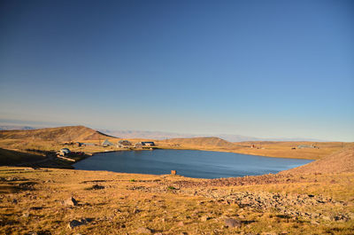 Scenic view of bay against clear blue sky