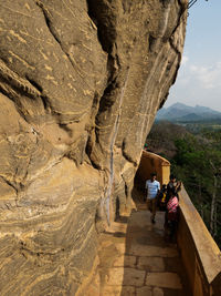 Rear view of people walking on rock