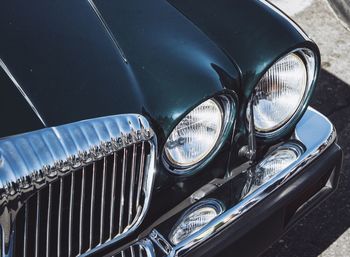 Cropped image of green vintage car parked on road