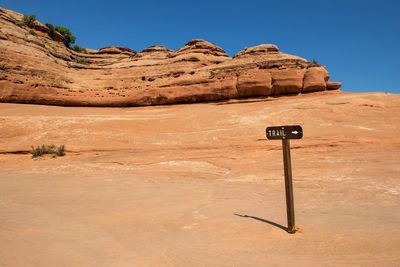 Information sign on mountain against clear sky