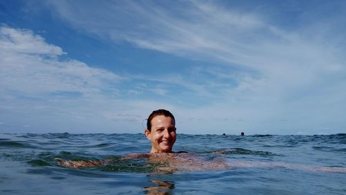 Portrait of woman swimming in sea against sky