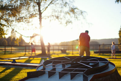 Rear view of man standing by tree against sky
