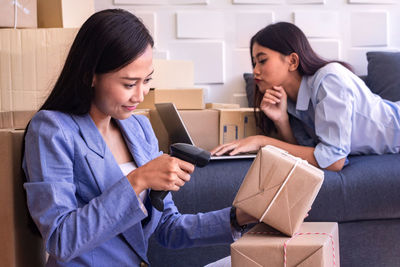 Young woman using mobile phone while sitting in office