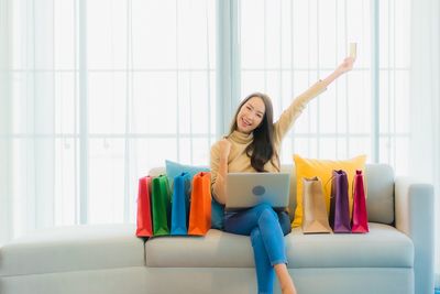 Young woman sitting on sofa