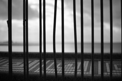 Close-up of metal railing against sea