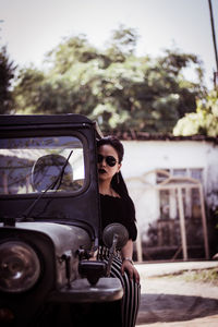 Portrait of beautiful young woman sitting on off-road vehicle