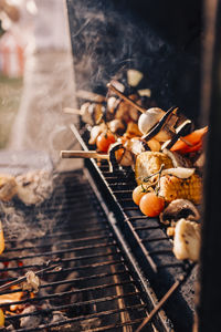 Vegetable skewers getting grilled on barbecue in back yard