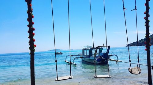 Deck chairs on beach against clear blue sky