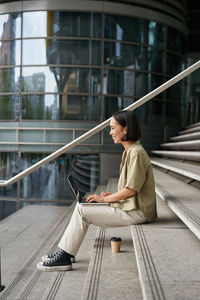 Side view of woman sitting on steps