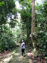 Portrait of woman walking on footpath in forest