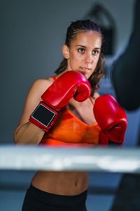 Female boxer practicing with male coach in gym