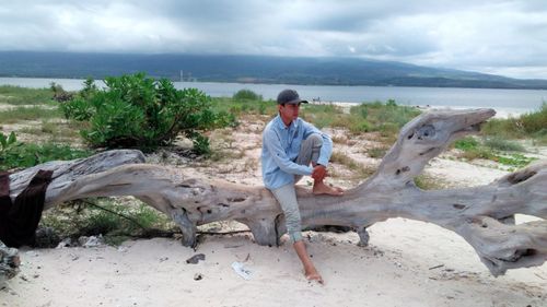 Full length of man sitting on beach