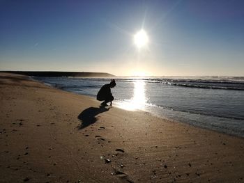 Silhouette man on beach against sky