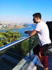 Side view of man leaning on railing 