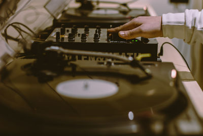 Cropped hand of man mixing music in dj club