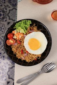 Indomie goreng or mie goreng, indonesian popular instant noodle. served with sunny side egg