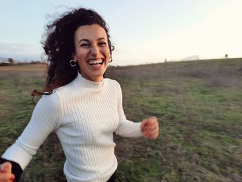 Portrait of young woman standing against sky