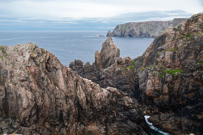 Rock formations by sea against sky