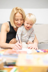 Portrait of smiling mother and daughter at home