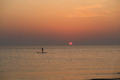 Scenic view of sea against orange sky